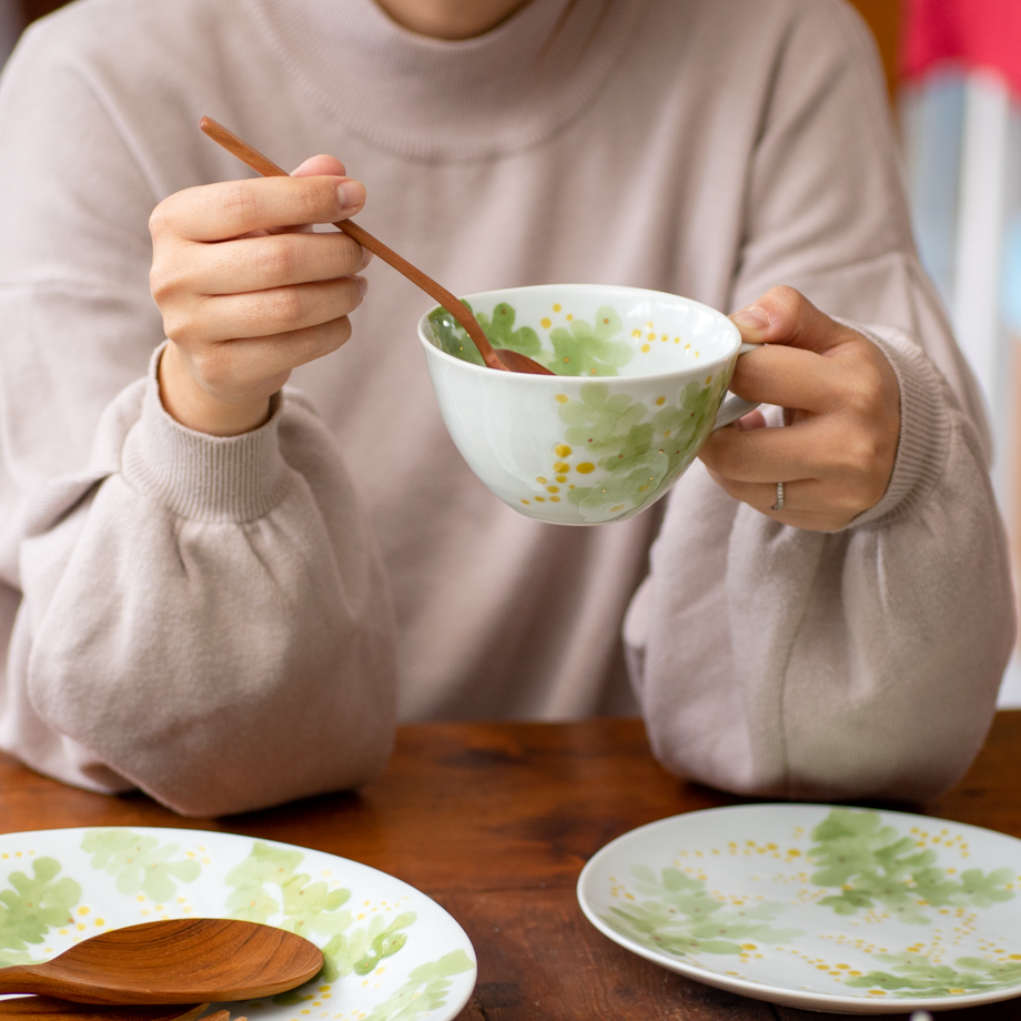 砥部焼窯元　東窯　ミモザシリーズスープカップを使ってスープを飲むイメージ